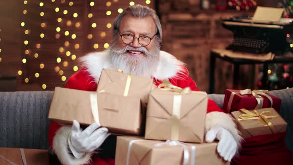 Portrait Male Santa Claus Posing with Heap of Wrapped Gift Boxes