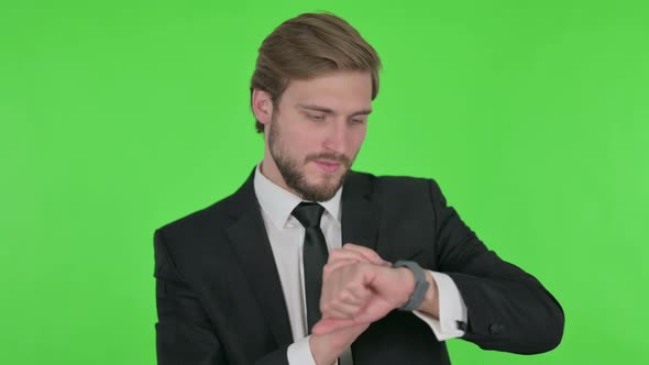 Young Businessman Using Smartwatch on Green Background