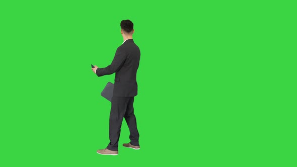 Young Business Man Walking and Taking a Selfie on a Green Screen, Chroma Key.