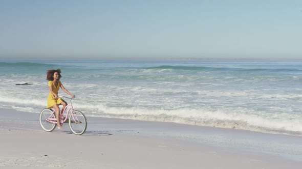 African American woman riding a bike seaside