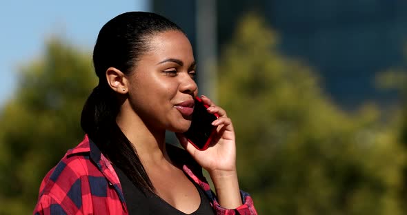 Happy young African woman talking on the mobile phone.