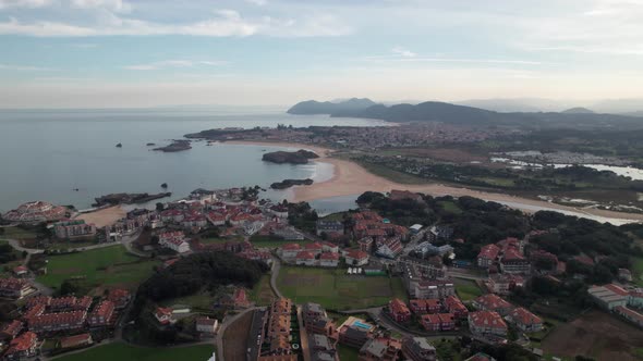 Large Spanish village of Suances with many red-roofed houses on the yellow sand beaches of the quiet