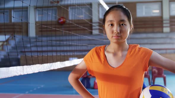 Female player holding volleyball in the court