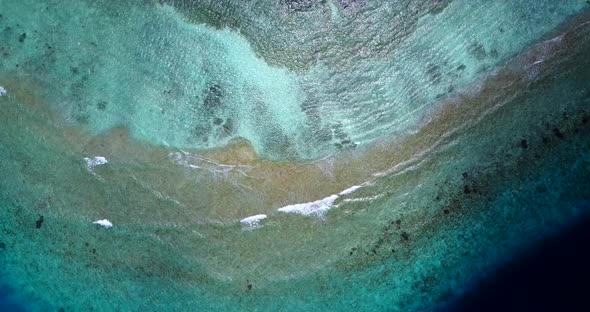 Wide angle above island view of a summer white paradise sand beach and aqua blue water background in