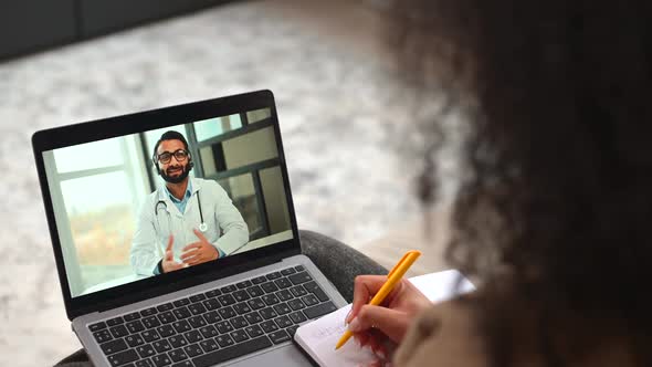 Young Multiracial Woman Sits on the Sofa at Home Making Video Call to Doctor