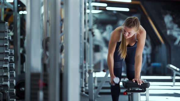 Fit Woman Exercising with Dumbbells in Gym