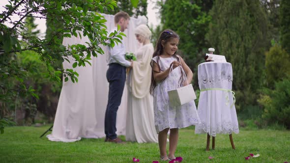 Cute Excited Middle Eastern Flower Girl Throwing Roses Petals Smiling with Blurred Happy Loving