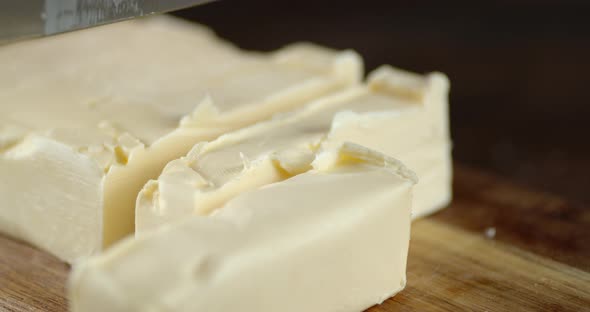 Men's Hands with a Knife Cut Off Pieces of Butter. 