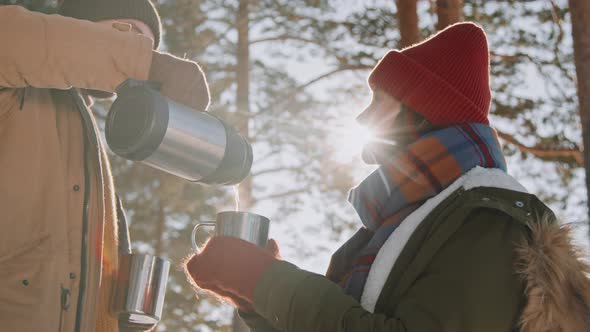 Couple Enjoying Hot Tea on Hike in Winter