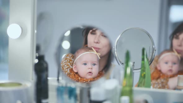 A Loving Mother and Her Child at the Makeup Mirror