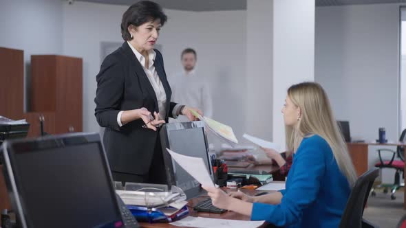 Portrait of Dissatisfied Caucasian Manager Talking with Young Irresponsible Employee in Office