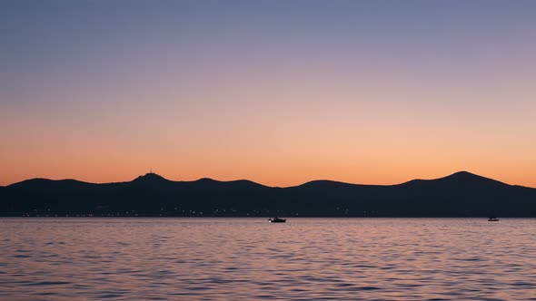 Timelapse of hills by the sea at dusk