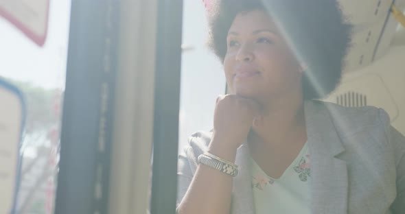 Happy plus size biracial woman sitting in bus