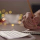 Slow Motion Orbit Shot Closeup Man Writes Shopping List Notepad Pencil Under Warm Light Evening - VideoHive Item for Sale