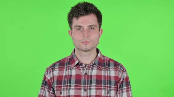 Portrait of Serious Young Man Looking at the Camera Green Chroma Screen