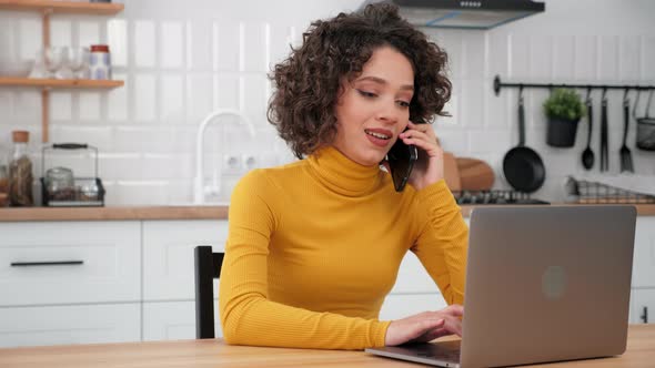 Smiling Hispanic Curly Woman Student Talking on Mobile Phone Using Laptop