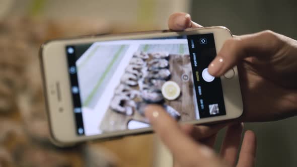 Female Hands Takes Photos with Fish Set on Phone Camera