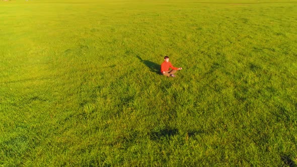 Low Altitude Radial Flight Over Sport Yoga Man at Perfect Green Grass