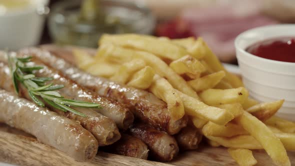 Bowl with Tomato Sauce and Smoked Sausages with Rotating French Fries Closeup