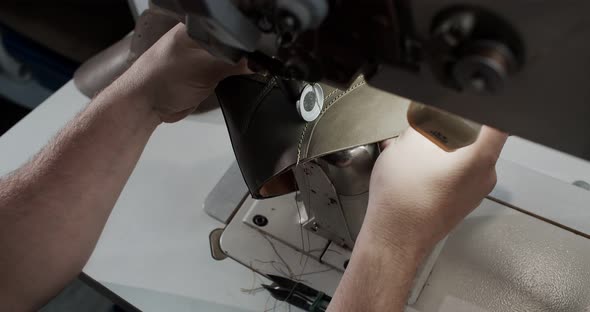 Top View of Tailor Works on Sewing Machine in Private Leather Craftshop Making Shoes in Process