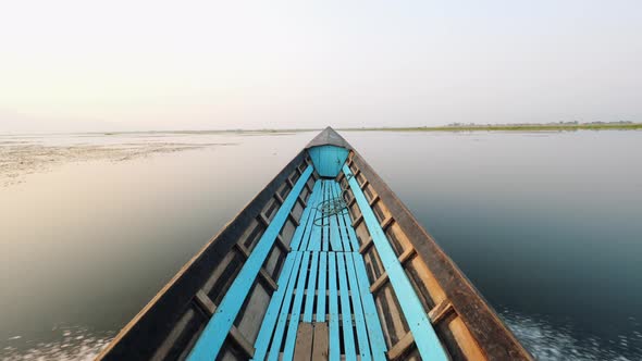 Old Blue Wooden Motor Boat Floats on the Calm River Water Surface Early Morning. Inle Lake, Myanmar