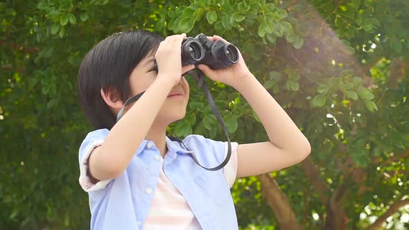 Cute Asian Child Using Binocular On Summer Day