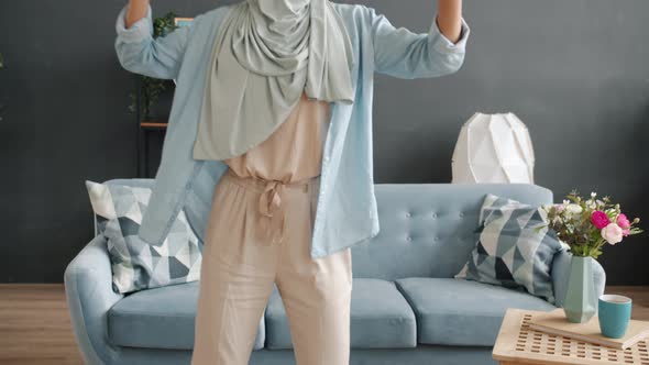 Portrait of Elegant Muslim Woman Wearing Hijab Dancing at Home Enjoying Leisure Time Alone