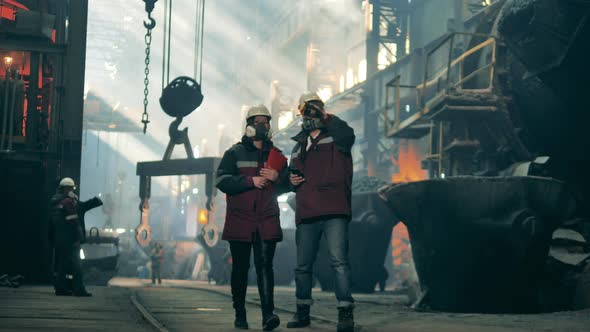 Steel Mill Colleagues in Safety Wear are Walking Along the Factory