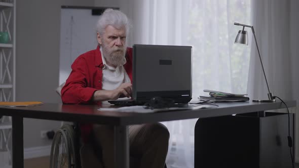 Tired Senior Disabled Man Closing Laptop Sighing Looking Up in Slow Motion