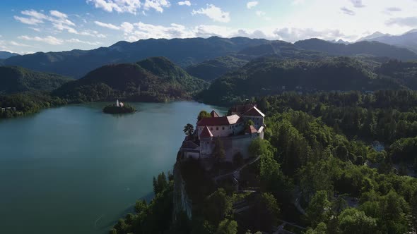 Stately Bled castle on precipice above city of Bled, Slovenia; drone view