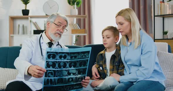 Doctor Visiting Patients at Home and Discussing with them Results of X-ray Scan