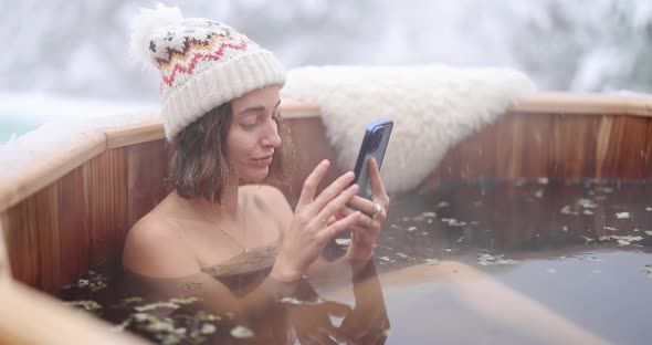 Woman Relaxing in Hot Bath at Snowy Mountains