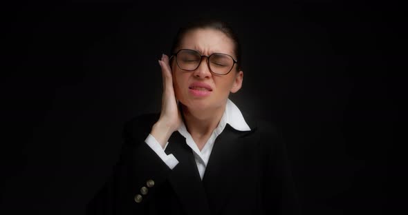 Business Woman in Glasses and Business Clothes Has a Sharp Pain in Her Ear