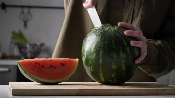 Man cut watermelon on desk on kitchen