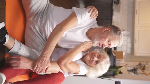 Portrait of a Cute Elderly Couple Dressed in Sports Clothes and Sitting on the Floor After a Morning