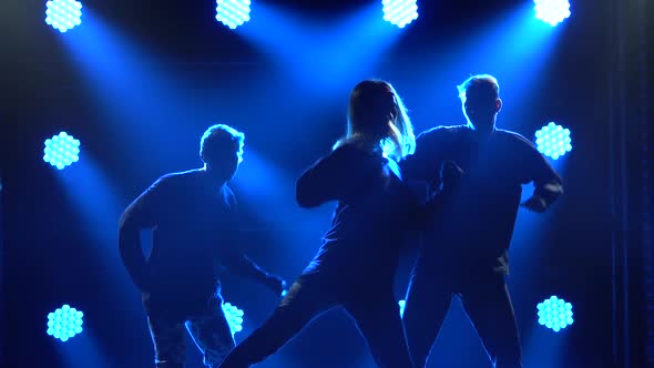 Silhouettes of a Talented Group Young Hip Hop Dancers. Hip Hop Street Dance on a Stage in Dark