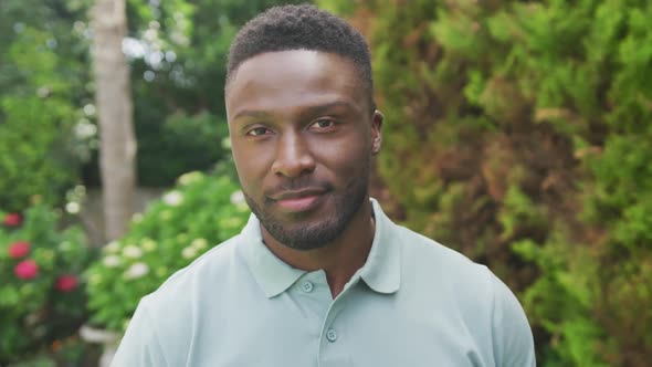 Portrait of smiling african american man looking at camera in garden