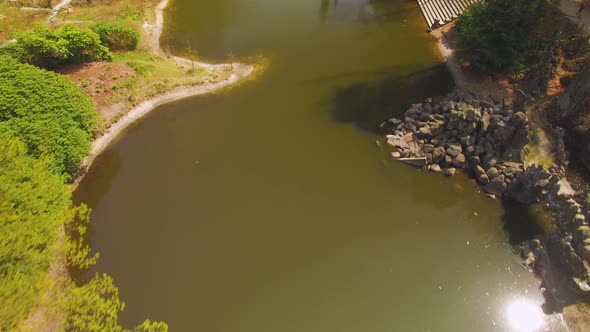 Drone footage of a small lake in kromlauer park, Germany with a beautifully designed cemented foot b