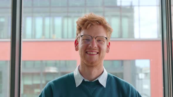 Young Ginger Irish Man in Glasses Crossing Hands on Chest Portrait