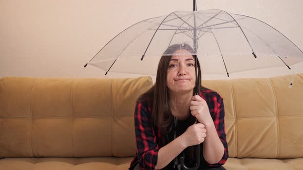 Pensive Woman Hides From Flowing Water Under Clear Umbrella