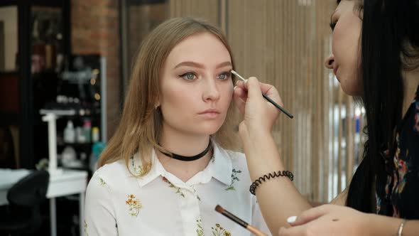 the Make-Up Stylist Doing a Make-Up to Hipster Model