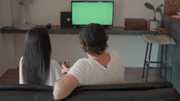 Man and Woman Sitting on Couch Playing Video Games on Green Screen