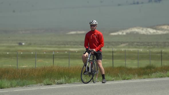 A man road biking on a scenic road.