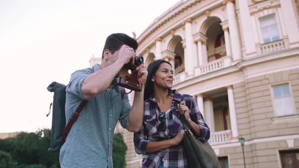 Young Mixed Race Tourist Couple Taking Pictures on Vintage Camera While Walking Through the City