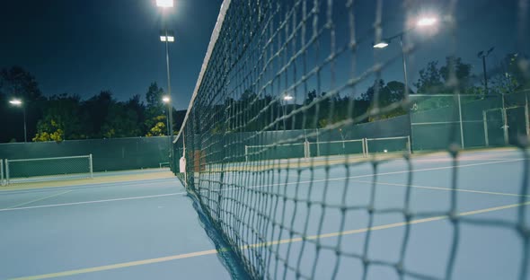 Small Yellow Ball Hitting Central Net Across the Court