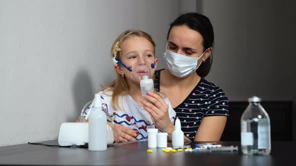Little Girl Uses Nebulizer for Treatment with Mom
