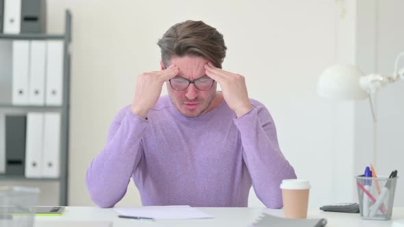 Middle Aged Man Having Headache in Office 