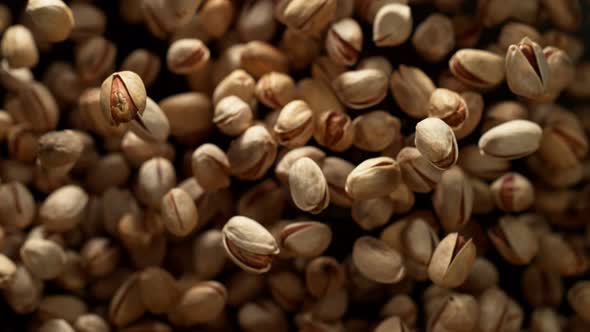 Super Slow Motion Shot of Pistachios Flies After Being Exploded Against Black Background, 1000Fps.