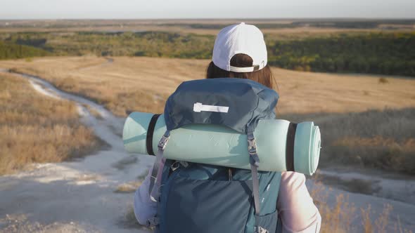 Woman Traveler with Backpack Walking in the Mountains Freedom and Happiness