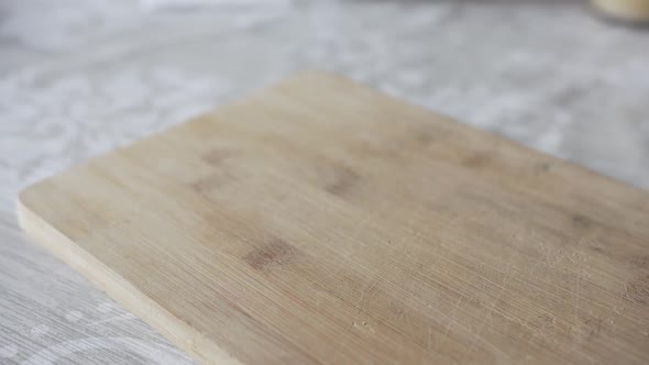 Man's Hand Puts Pepper on the Cutting Board